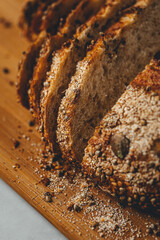 Close up view on freshly baked sourdough bread on wooden cutting board on bright backgrounda