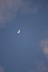 Obraz na płótnie Canvas Rosa beleuchtete Wolken am Himmel am Abend leuchten mit Mond (Halbmond)