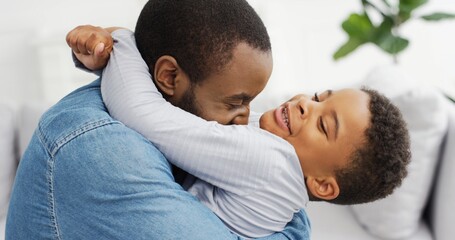 Portrait of African American dad hugging his little son. Happy Father's day.