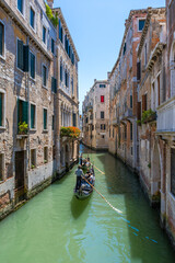 Fototapeta na wymiar Classical picture of the venetian canals with gondola.
