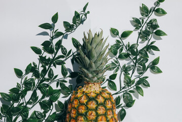 ripe juicy tropical pineapple on a yellow-white background. Space for text. Pineapple on a wooden table