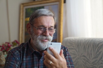 Senior man using smartphone. Smiling.