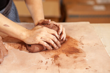 hands of a potter at work with clay in an art studio