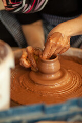 hands of a potter at work in an art studio