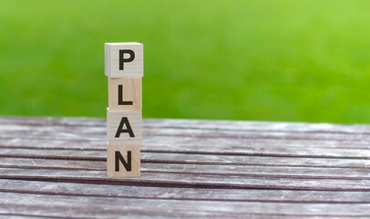 Text of plan on wooden cubes.Business strategy and marketing concept, Wooden letters, with word PLAN on green background