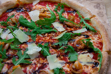 Haute Italian cuisine. Fresh pizza with shrimps and arugola. Closeup