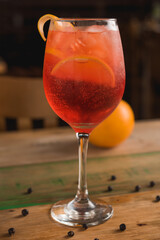 Classic Italian Aperol Spritz cocktail, with lemon in the background