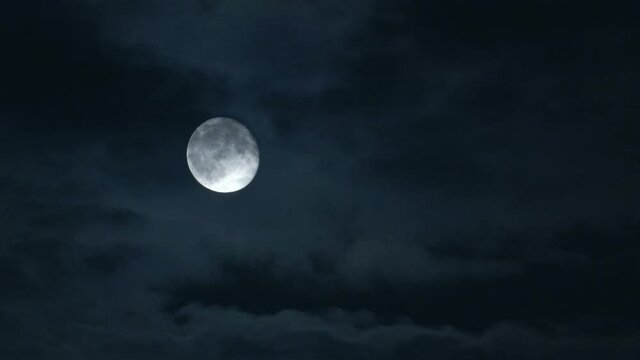 Dramatic night shot of a bright moon with a cloudy sky, the Netherlands.
