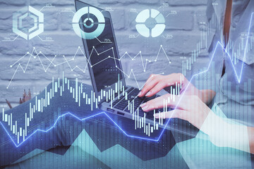Multi exposure of woman hands typing on computer and forex chart hologram drawing. Stock market...
