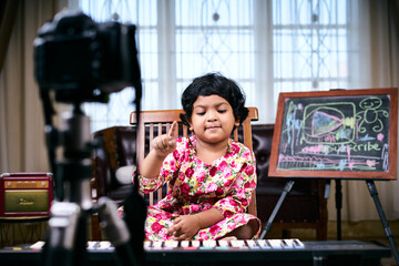 Happy Little girl making video tutorial how to play piano