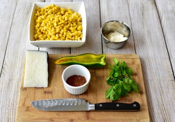 Measured and whole ingredients ready for making simple and tasty fresh street corn salad at home or in a cooking class