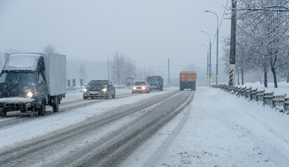 Heavy snow in the city, roadway with cars in the snow, ice.