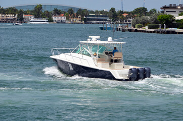 Fototapeta na wymiar Upscale fishing boat powered by three outboard engines cruising on Biscayne Bay off of Miami Beach,Florida