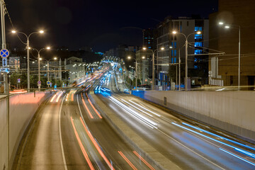 Cityscape with a highway, traffic light and cars, shot at long exposure.