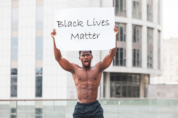 black lives matter concept. aggressive African American with a poster protests and shouts, America...