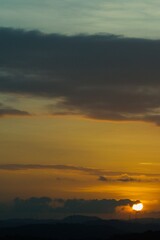 warm summer sunset with sun and clouds