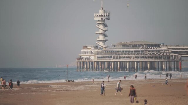 Famous Dutch pier in Scheveningen beach, tourist destination in The Netherlands, hot summer day with fata morgana near Amsterdam