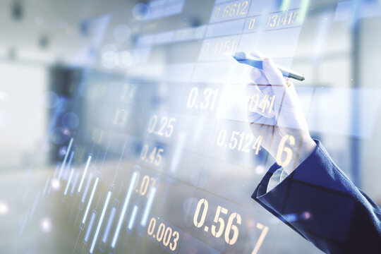 Multi exposure of trader hand with pen working with virtual abstract financial graph interface on blurred office background, financial and trading concept
