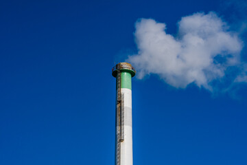 Column of smoke rising from tall smokestack