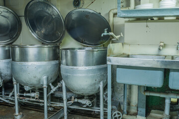 Industrial pressure cookers next to double sink