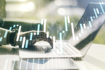 Double exposure of abstract creative financial chart with hand typing on computer keyboard on background, research and strategy concept