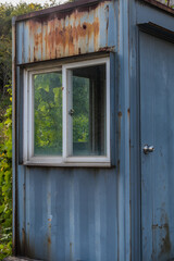 Fototapeta na wymiar Abandoned rusted metal guardhouse