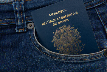 Brazilian passport in jeans pocket with Real notes. International travel and tourism concept. Business trip.Translate: Mercosur - Federative republic of Brazil. Old Blue passport.