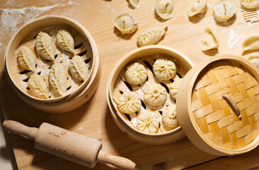 Buns and dumplings in bamboo steamer, raw handmade food, homemade Chinese snack