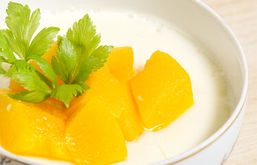 Closeup of mango pudding with milk, homemade fruit dessert, summer sweet food