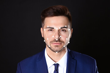 Facial recognition system. Businessman with digital biometric grid on dark background