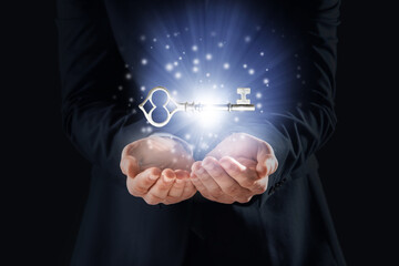 Businessman holding golden key on dark background, closeup