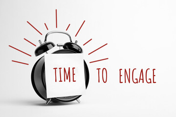 Alarm clock with note and phrase TIME TO ENGAGE on white background