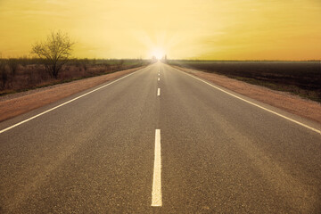 Obraz premium Road trip. Beautiful view of asphalt highway at sunset