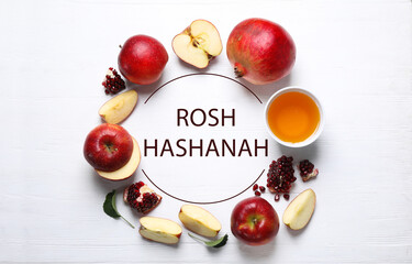 Frame of honey, apples and pomegranates on white wooden table, flat lay. Rosh Hashanah holiday