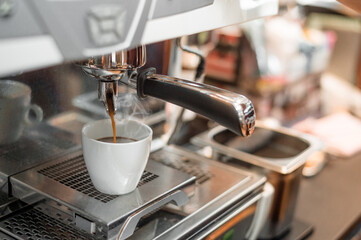 black coffee in white cup put on coffee maker