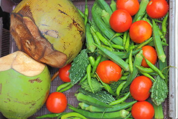 tender coconut tomato bitter gourd kept on tray