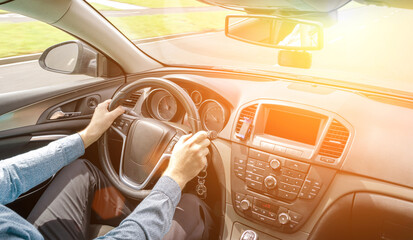 Driver training car on road in summer sunny day. Happy young man inside vehicle driving. Vacation...