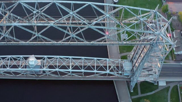 Aerial overhead view lift bridge in down position over canal in Duluth, Minnesota off the shore of Lake Superior - drone high angle shot