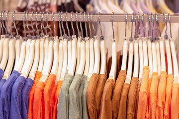 Multicolored things of pastel shades hang on white shoulders, side view