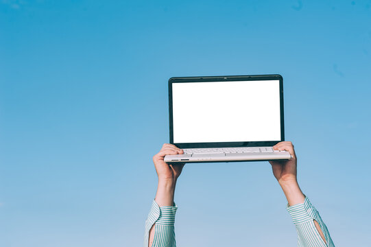 Mock up laptop in the hands of a man, against the sky. - Powered by Adobe