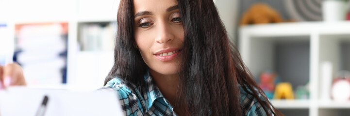 Musician looks at note for guitar on music stand. Training in reading from sheet notes for quick memorization composition. Music teacher reviews new material for playing instrument