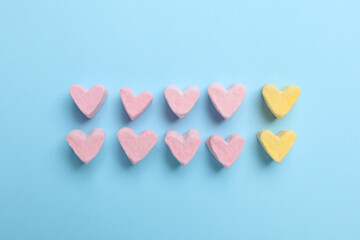 Flat lay composition with marshmallow hearts on light blue background. Pareto principle concept