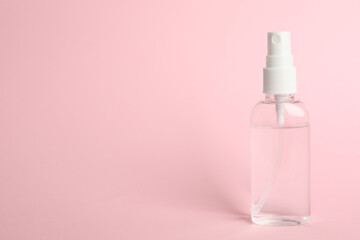 Antiseptic spray on pink background. Space for text