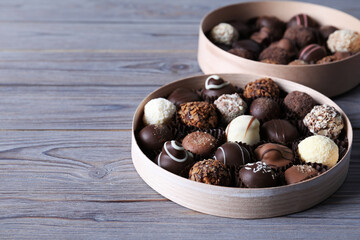 Boxes with tasty chocolate candies on wooden table