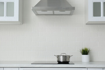 Fototapeta na wymiar Saucepot on induction stove in stylish kitchen interior