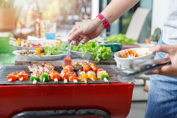 Obraz premium A man grilling pork and barbecue in dinner party. Food, people and family time concept.