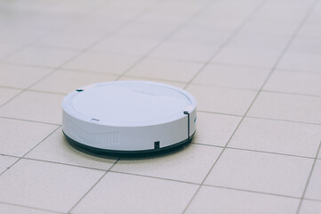 Smart robot vacuum cleaner on a tile floor.