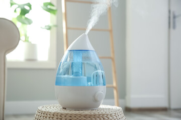 Modern air humidifier on wicker pouf indoors - obrazy, fototapety, plakaty