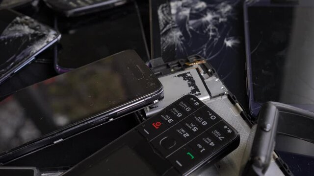 Obsolete old smartphones and broken cell phones with cracked screen. Mobile phone recycling. Used digital tablets and smart watch. Hazardous waste. Recycle e-waste
