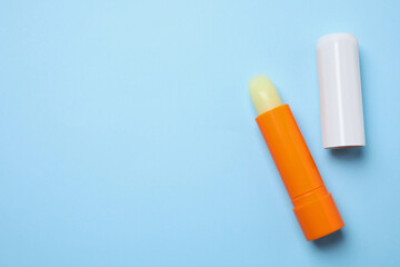 Hygienic lipsticks on light blue background, flat lay. Space for text